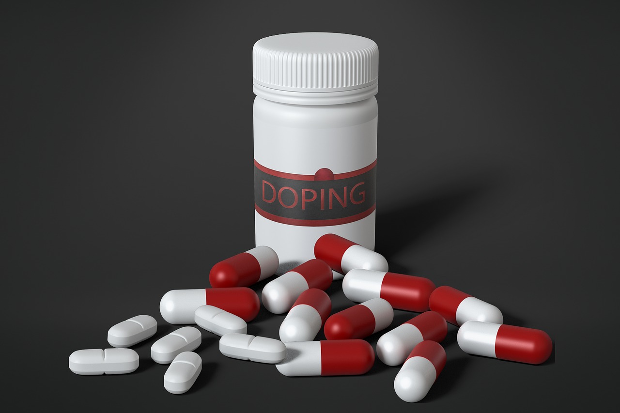 Eine Dose mit der Aufschrift Doping. Davor sind unterschiedliche Tabletten verstreut.